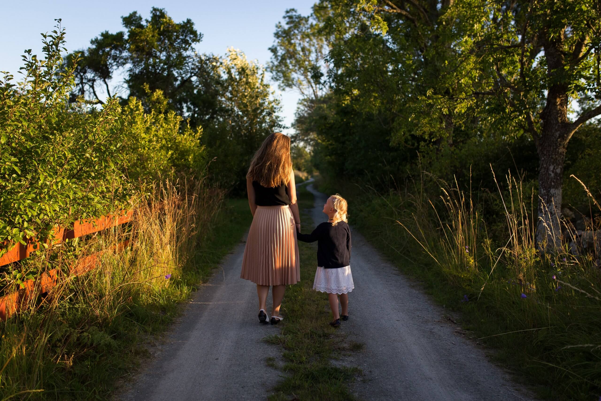 mãe e filha a passear pelos campos de mão dada